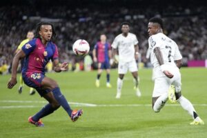 Duel antara Jules Kounde dan Vinicius Junior pada laga El Clasico pekan ke-11 La Liga 2024/2025 (c) AP Photo/Bernat Armangue