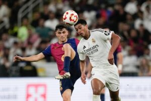 Duel Pedri dan Jude Bellingham dalam laga final Supercopa de Espana antara Real Madrid vs Barcelona, Senin (13/1/2025). (c) AP Photo/Altaf Qadri