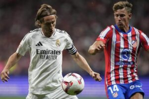 Duel Luka Modric dan Marcos Llorente dalam laga laga Atletico Madrid vs Real Madrid di La Liga 2024/2025, Senin (30/9/2024). (c) AP Photo/Bernat Armangue