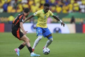 Kualifikasi Piala Dunia 2026: Vinicius Junior (kanan) vs Daniel Munoz di laga Brasil vs Kolombia, 21 Maret 2025 (c) AP Photo/Eraldo Peres