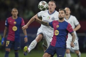 Davide Frattesi dan Inigo Martinez berebut bola dalam laga Barcelona vs Inter Milan di leg pertama semifinal Liga Champions 2024/2025, Kamis (1/5/2025) dini hari WIB. (c) AP Photo/Emilio Morenatti