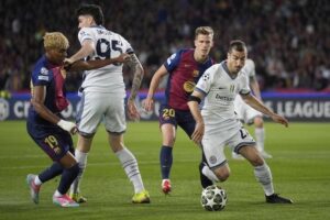 Henrikh Mkhitaryan beraksi di depan Dani Olmo dalam laga Barcelona vs Inter Milan di leg pertama semifinal Liga Champions 2024/2025, Kamis (1/5/2025) dini hari WIB. (c) AP Photo/Emilio Morenatti